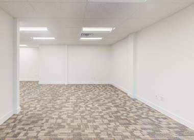 A room with a carpeted floor and white walls.