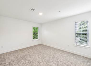Wesley St. Claire Apartments at Lawrenceville bedroom with carpet and two windows - Lawrenceville, GA