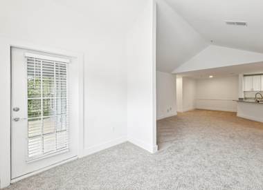 Wesley St. Claire Apartments at Lawrenceville living room with carpet and vaulted ceiling - Lawrenceville, GA