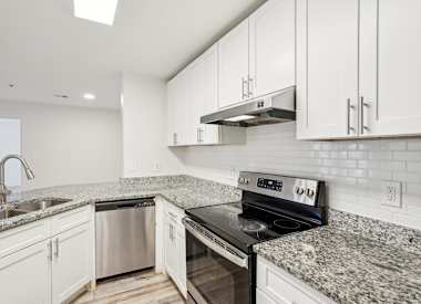 Wesley Hampstead Apartments at Douglasville kitchen with granite countertops and stainless steel appliances - Lithia Springs, GA