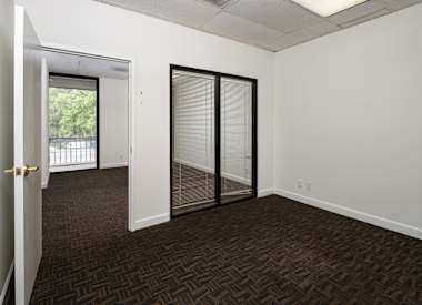 A room with a carpeted floor and a sliding glass door.