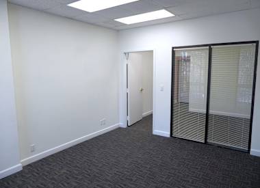 A room with a carpeted floor and a glass door.