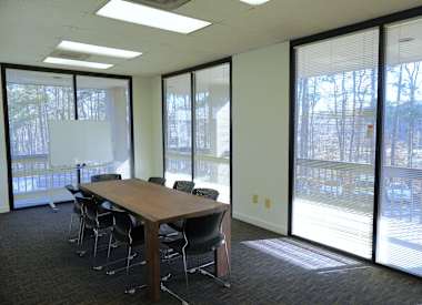 A conference room with a long table and chairs.