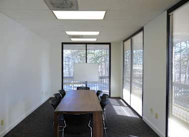 A conference room with a long table and chairs.
