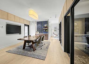 A modern dining room with a wooden table and chairs.