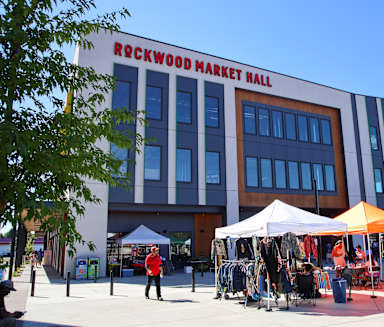 the building of the rexwood market mall with tents in front of it