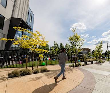 a man walking on a sidewalk next to a building