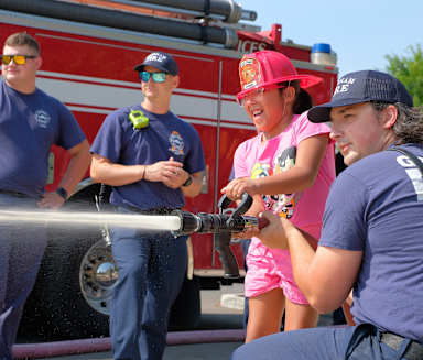 a group of people spraying water on a fire truck