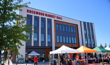 the building of the rexwood market mall with tents in front of it