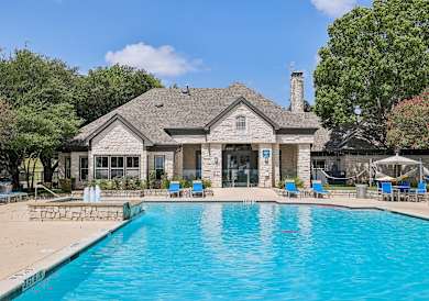 A house with a pool in front of it.