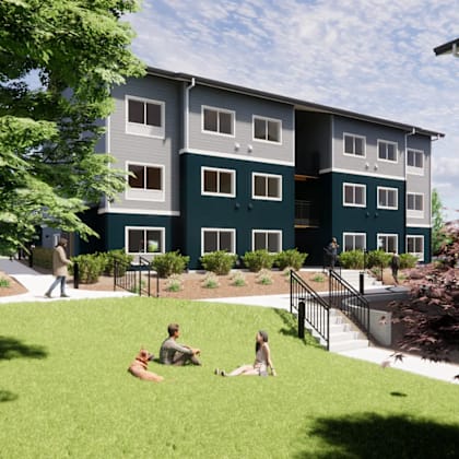 a group of people are sitting on the grass in front of a building.