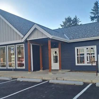 a small building with a parking lot in front.