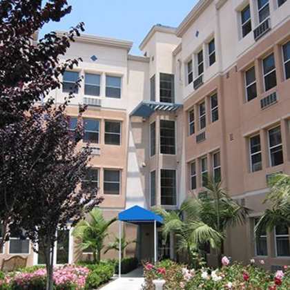 a building with a blue awning and a white fountain in front of it.