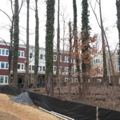 a construction site with a black tarp and a building in the background.