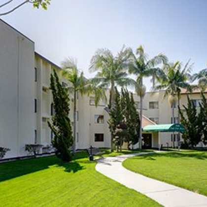 a sunny day at a residential area with apartment buildings and a green lawn.
