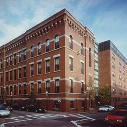 a red brick building with a black car parked in front.