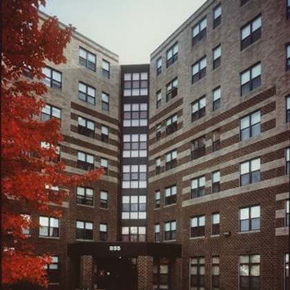 a tall brick building with a black awning in front.
