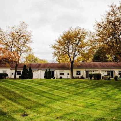 a large white building with a green lawn in front of it.