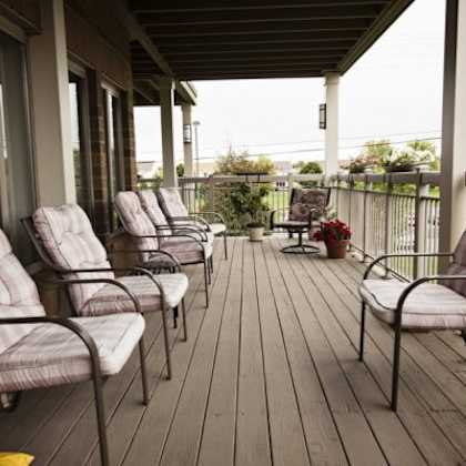 a porch with four chairs and a table.