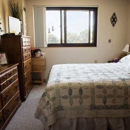 a bedroom with a bed, dresser, and mirror.