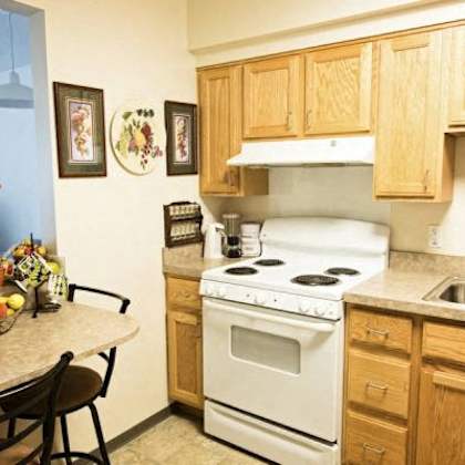 a kitchen with a white stove and wooden cabinets.