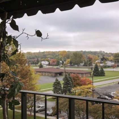 a view from a balcony overlooking a parking lot and a building.
