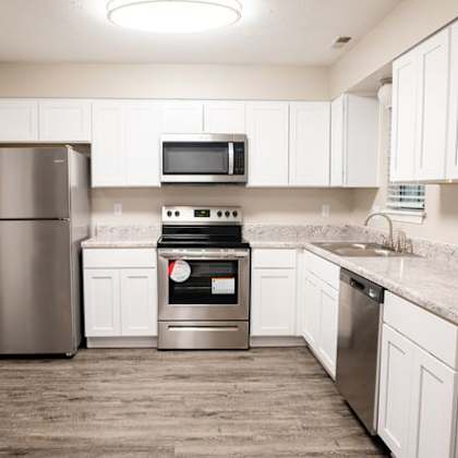 a kitchen with white cabinets and a stainless steel refrigerator.