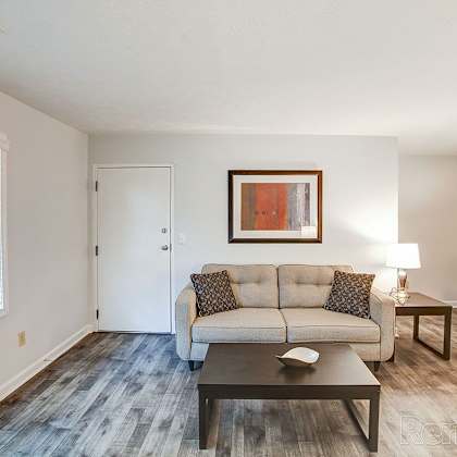 a living room with a couch, coffee table, and a painting on the wall.