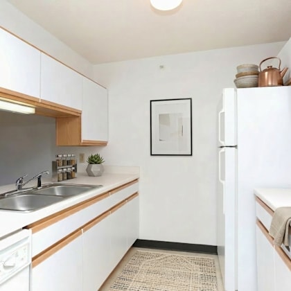 a kitchen with white cabinets and a fridge.