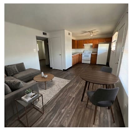 a living room with a grey couch, a coffee table, and a dining table.