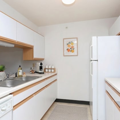 a kitchen with white cabinets and a white fridge.