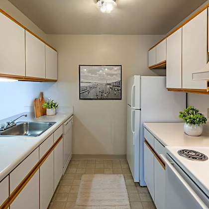 a kitchen with white appliances and wooden cabinets.