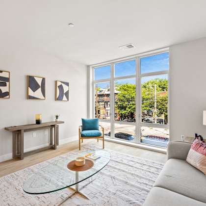 a living room with a couch and a chair and a large window