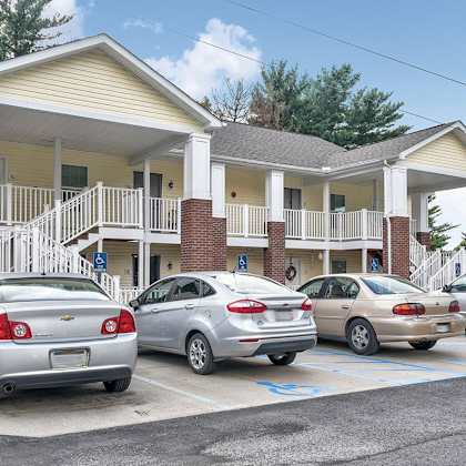 a parking lot with cars and a building in the background.