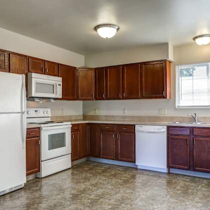 a kitchen with wooden cabinets and white appliances