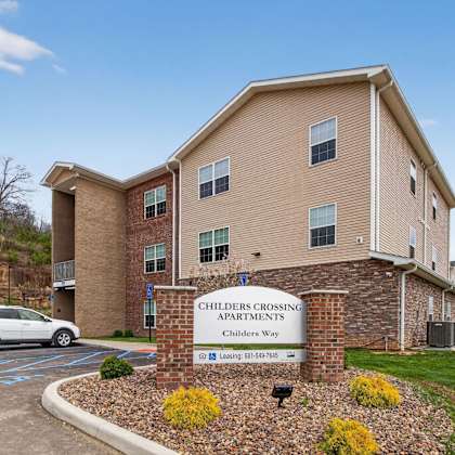 a building with a sign that says children's crossing apartments.