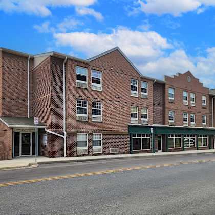 a brick building with an flag in front of a street