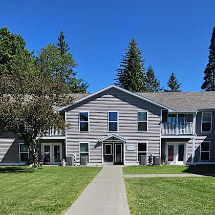 a grey building with a walkway in front of it.