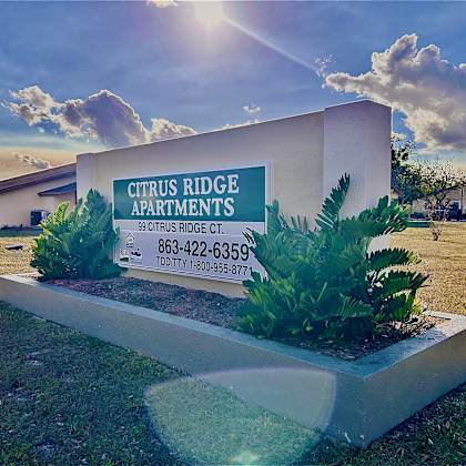 a sign for citrus ridge apartments with a phone number and address.