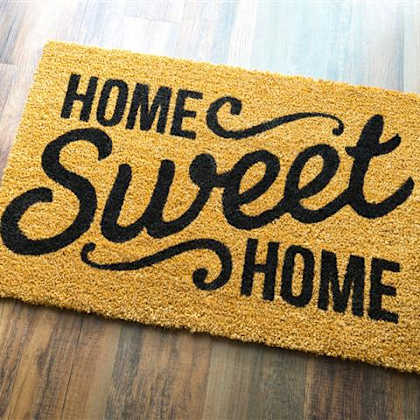 a doormat that says "home sweet home" on a wooden floor.