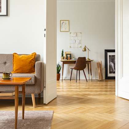 a living room with a grey sofa and a wooden table.