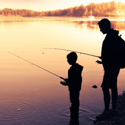 a man and a child are fishing by the water.