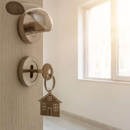 a door knob with a house shaped keychain on the door