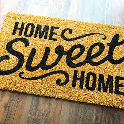 a doormat that says "home sweet home" on a wooden floor.