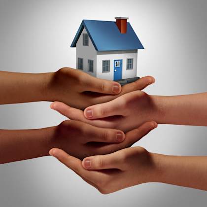 a family holding a house in their hands