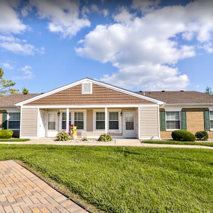 a house with a lawn and a walkway in front of it