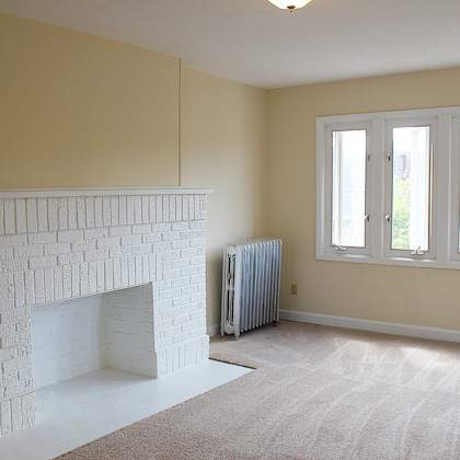 a white fireplace in a carpeted living room.