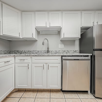 a kitchen with white cabinets and a stainless steel refrigerator.