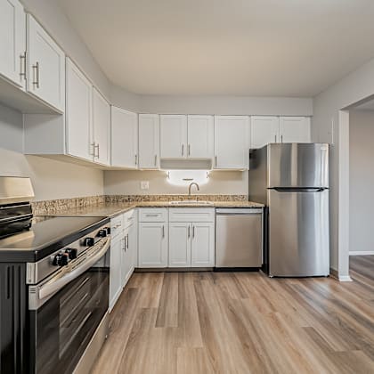 a kitchen with a black stove top oven and white cabinets.