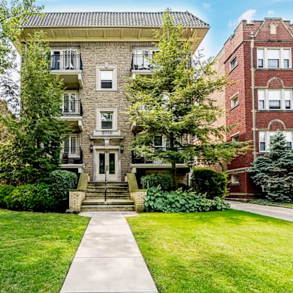 a large brick building with a tree in front of it.